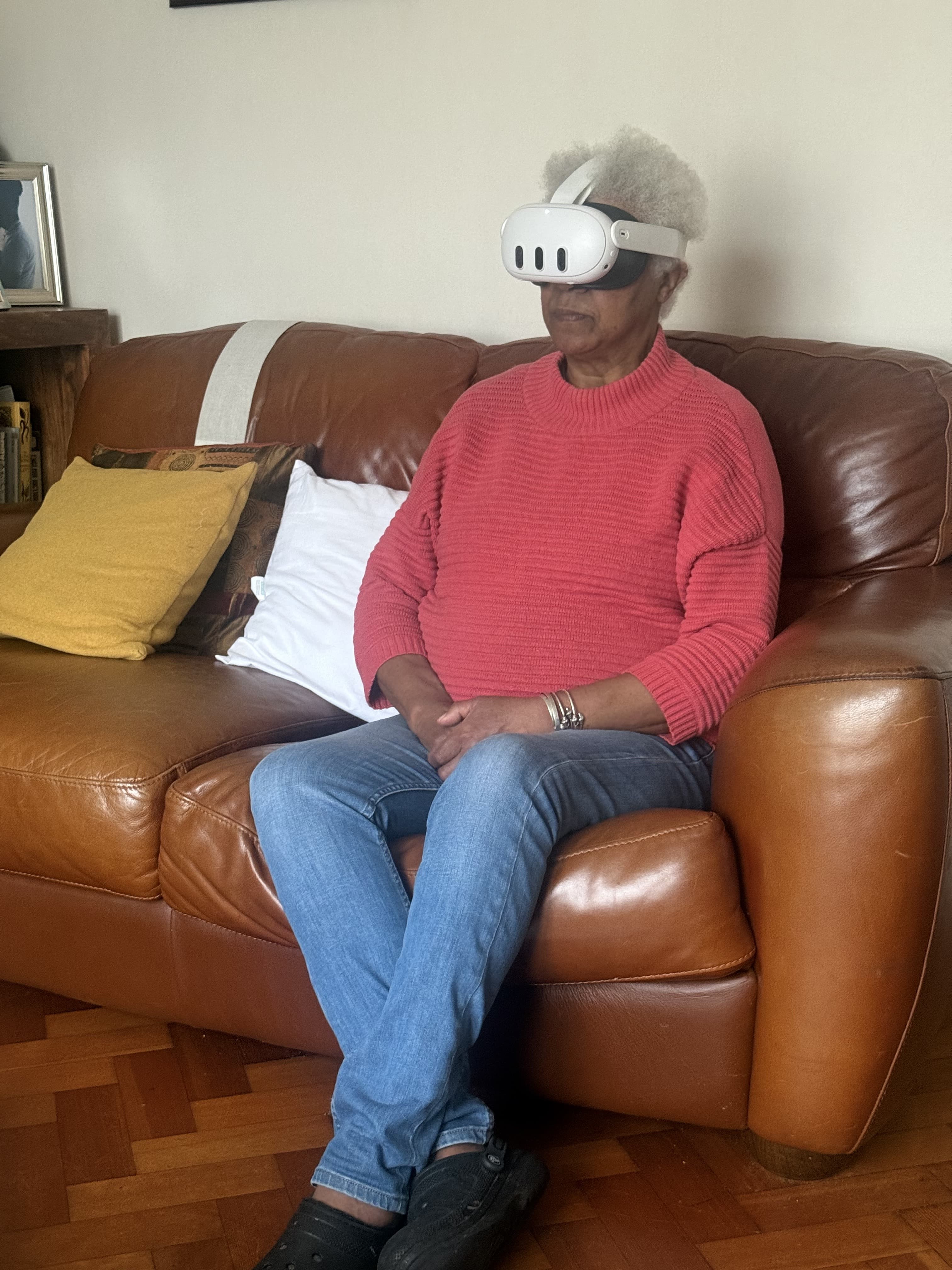 Elder woman using VR headset on couch
